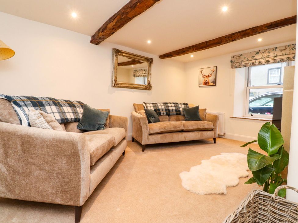 A living room with sofas and a painting at Cobble Cottage in Gisburn