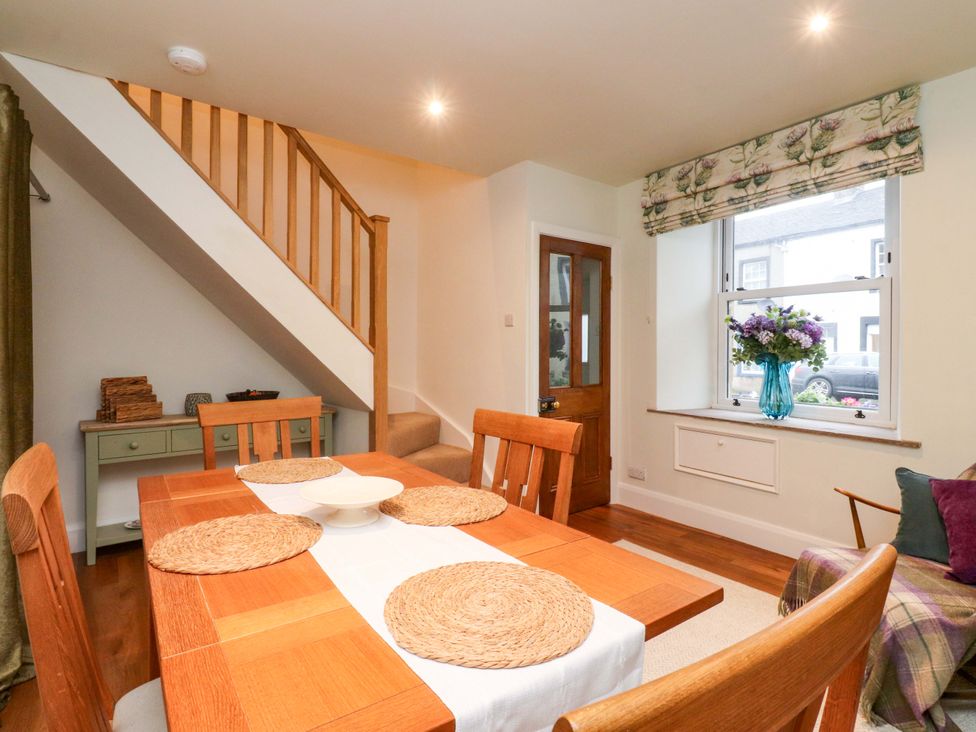 A dining room with a table and chairs at Cobble Cottage in Gisburn