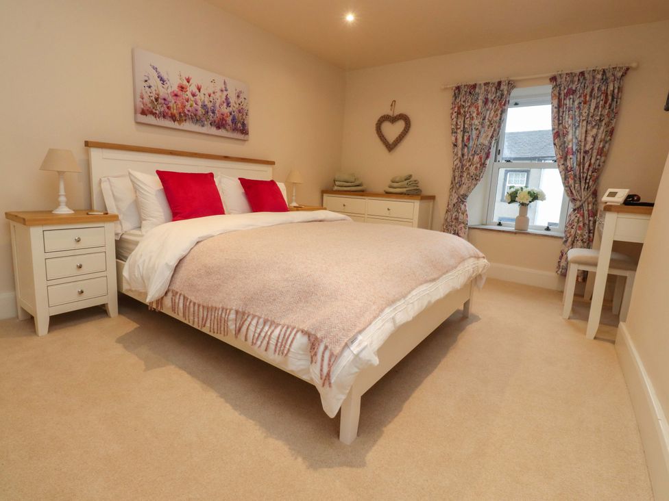 A bedroom with a bed and nightstands at Cobble Cottage in Gisburn
