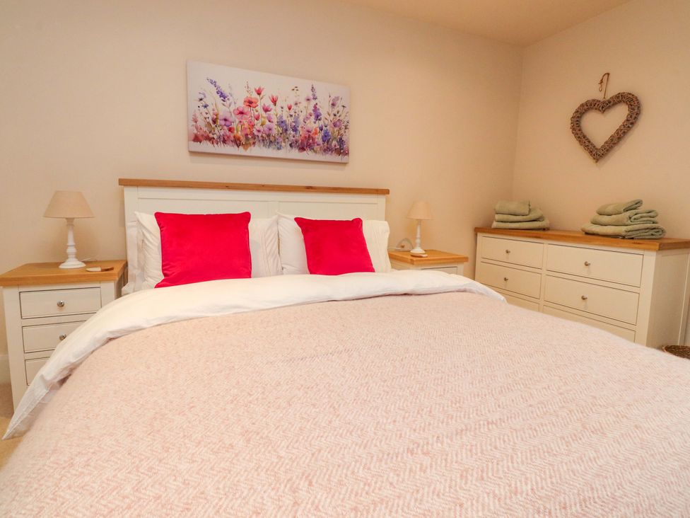 A bedroom with a bed and dresser at Cobble Cottage in Gisburn