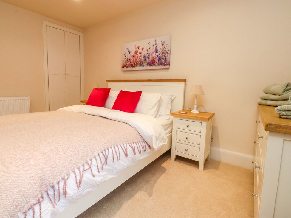 A bedroom with a bed and nightstand at Cobble Cottage in Gisburn