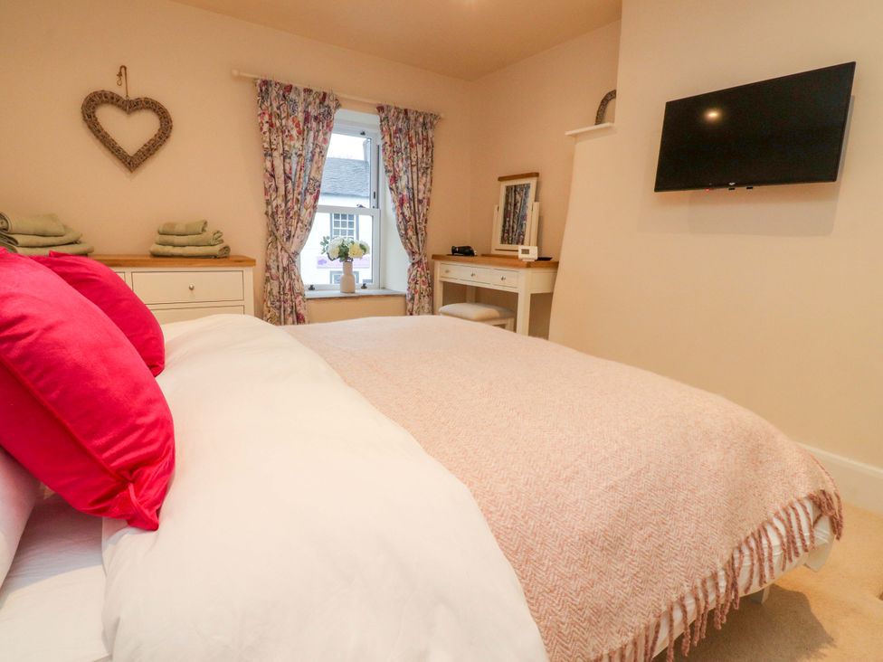 A bedroom with a bed and television at Cobble Cottage in Gisburn