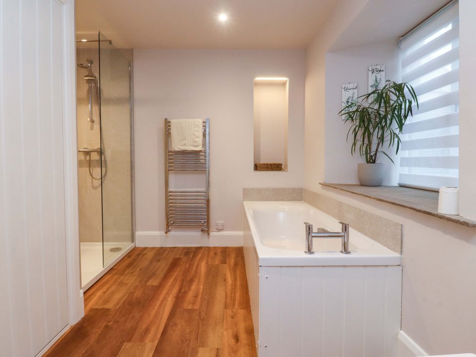 A bathroom with a bathtub and shower at Cobble Cottage in Gisburn