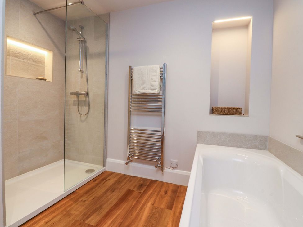 A bathroom with a shower and bathtub at Cobble Cottage in Gisburn