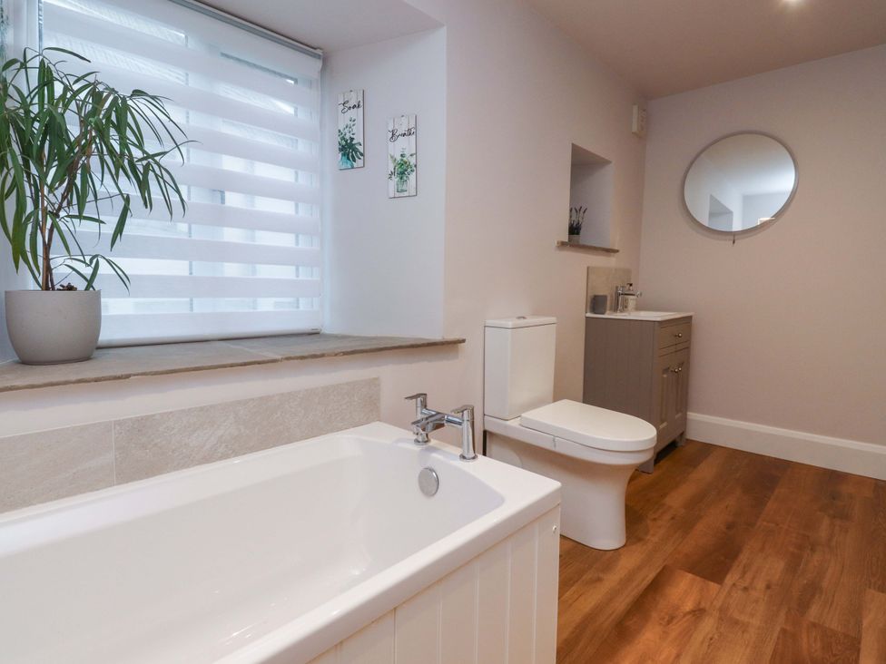 A bathroom with a bathtub and sink at Cobble Cottage in Gisburn