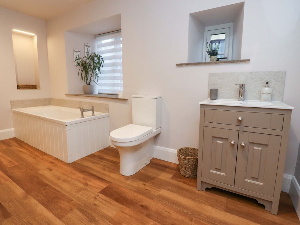 A bathroom with bathtub, toilet, and sink at Cobble Cottage in Gisburn