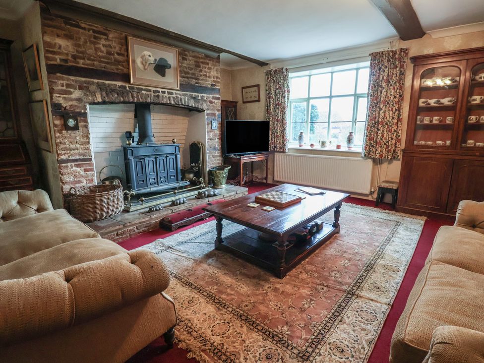 A living room with a fireplace and sofa at Farmhouse in Beccles