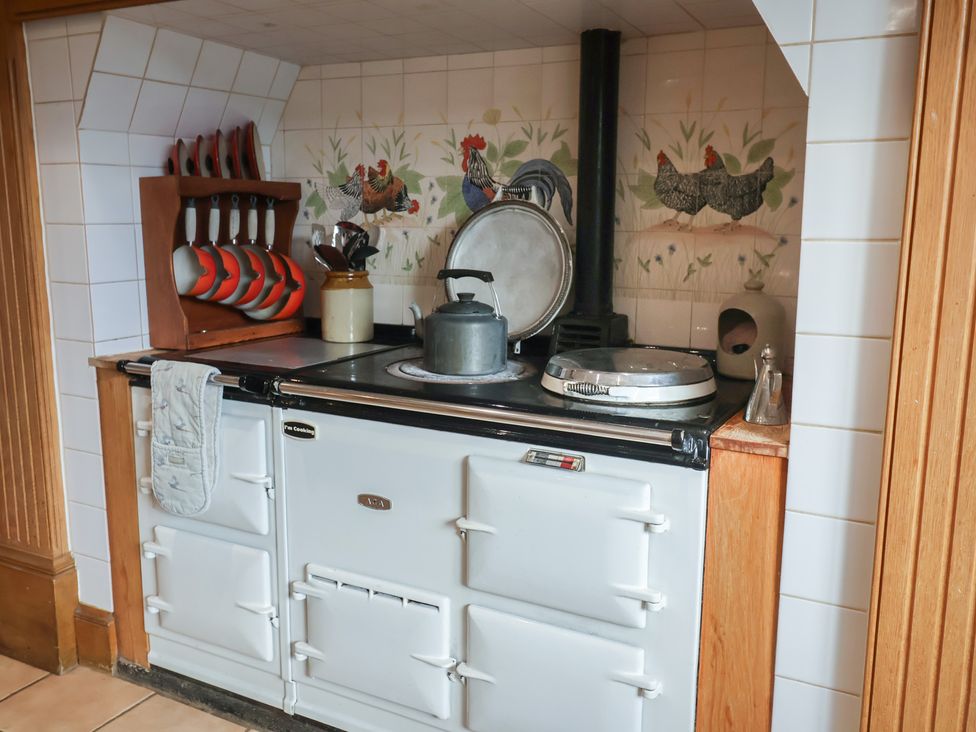 A kitchen with a stove and utensils at Farmhouse in Beccles