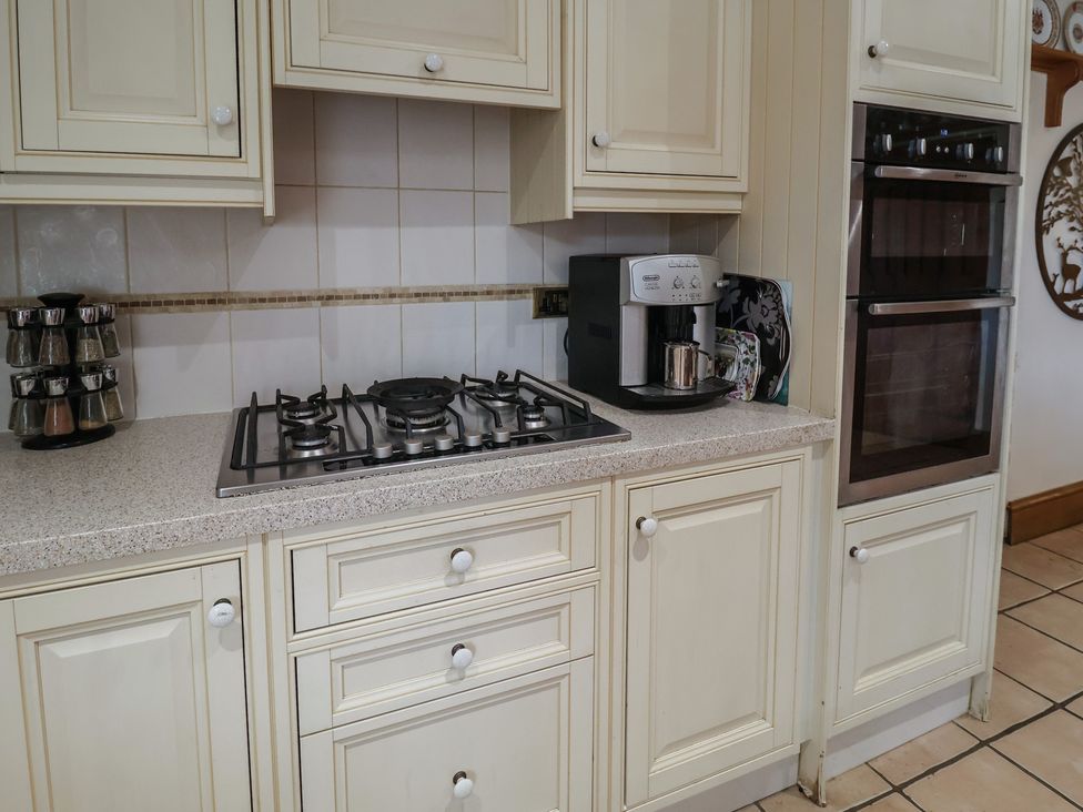 A kitchen with a stove and coffee maker at the Farmhouse in Beccles