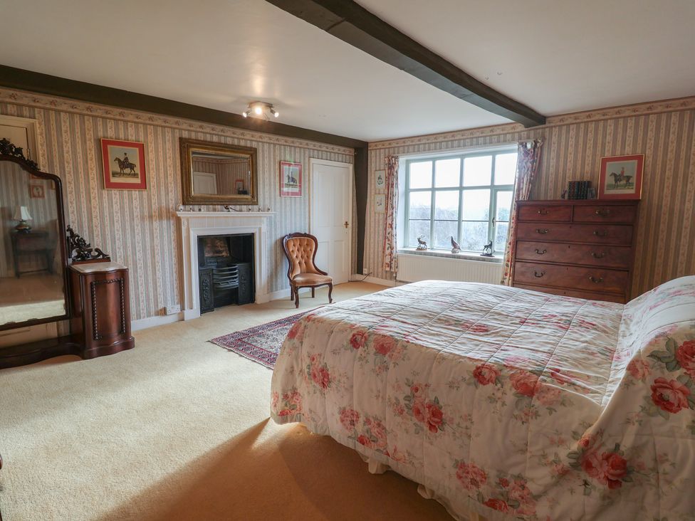 A bedroom with a bed and a fireplace at Farmhouse in Beccles