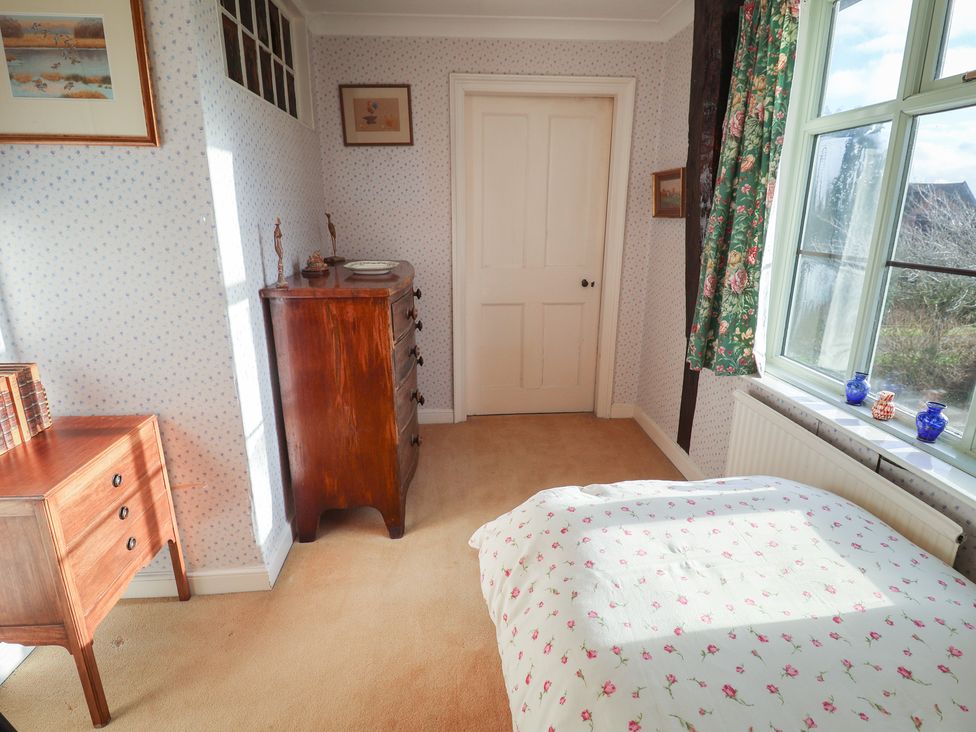 A bedroom with a bed and furniture at Farmhouse in Beccles