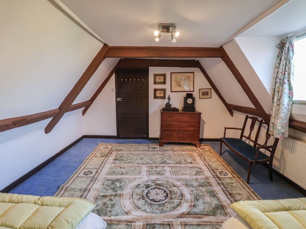A bedroom with furniture and a rug at the Farmhouse in Beccles