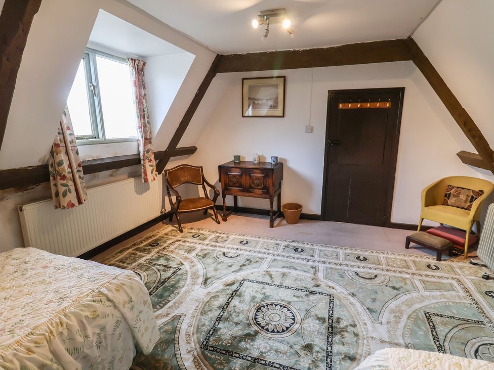 A bedroom with a bed, table, and window at the Farmhouse in Beccles