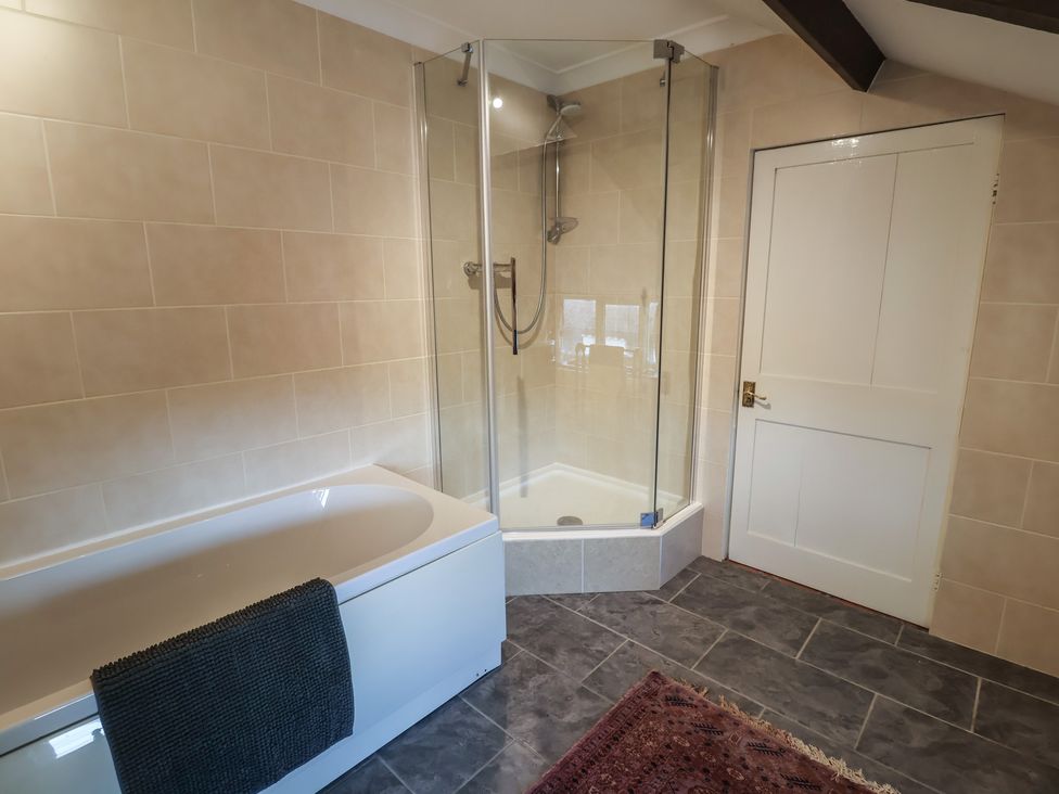 A bathroom with a bathtub and a shower at the Farmhouse in Beccles