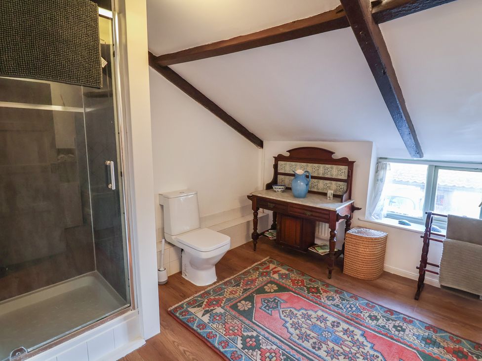 A bathroom with a shower, toilet, and vanity at the Farmhouse in Beccles