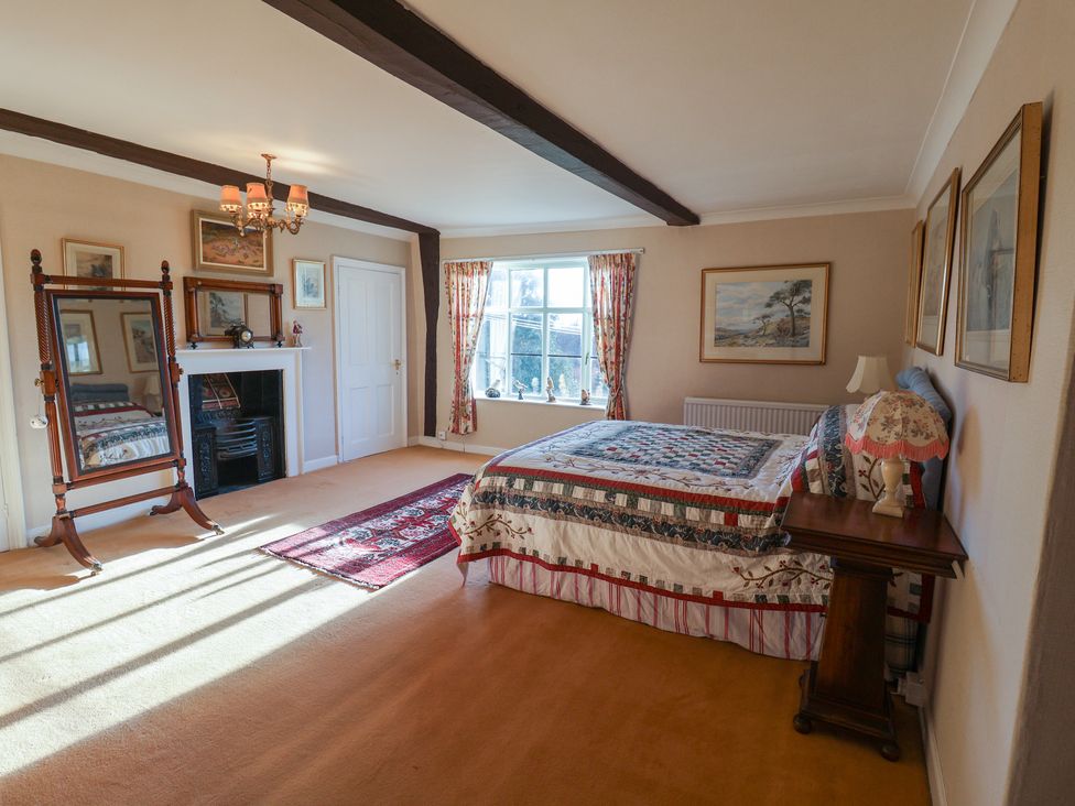 A bedroom with a bed and a mirror at the Farmhouse in Beccles
