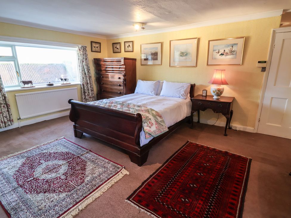 A bedroom with a bed and a dressing table at Farmhouse in Beccles