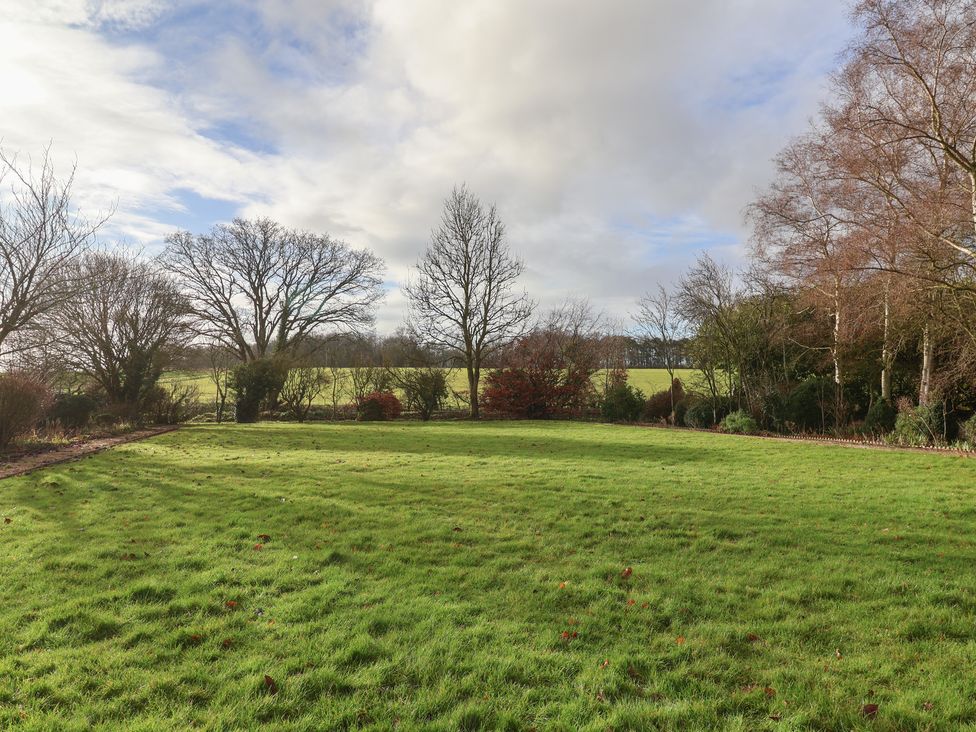 A garden with grass and trees at the Farmhouse in Beccles