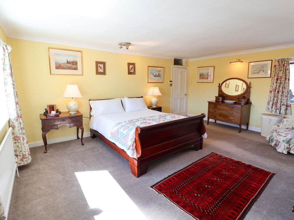 A bedroom with a bed and dresser at Winston Hall in Beccles