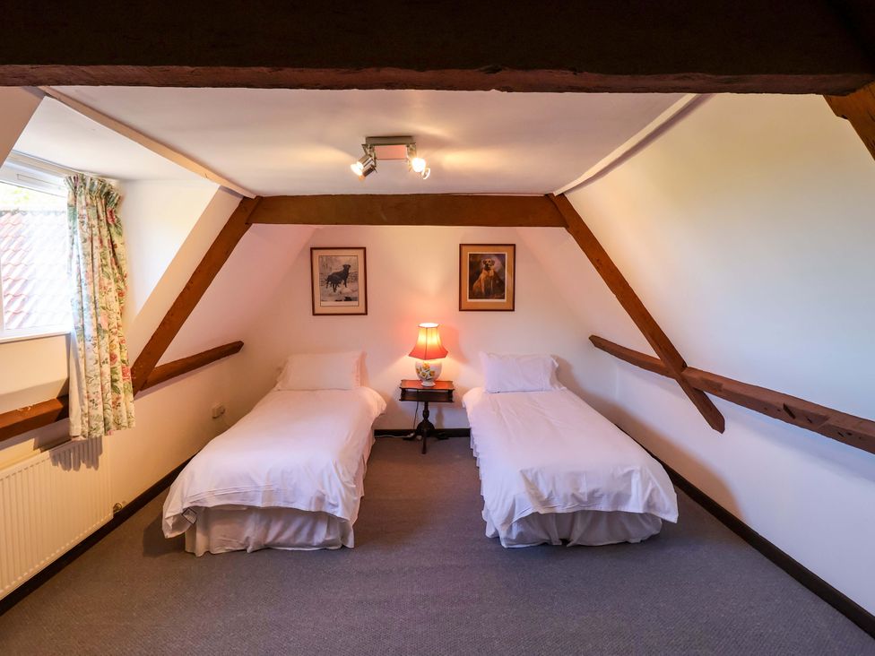A bedroom with two single beds and a table lamp at Winston Hall in Beccles