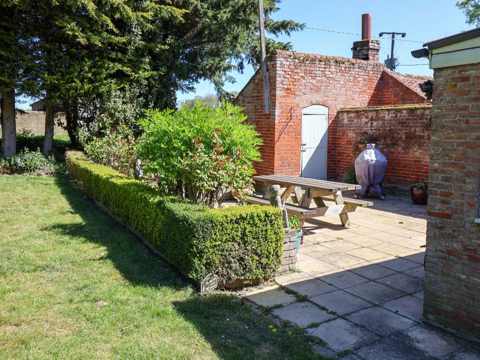 A garden with a patio table and grill at Winston Hall in Beccles