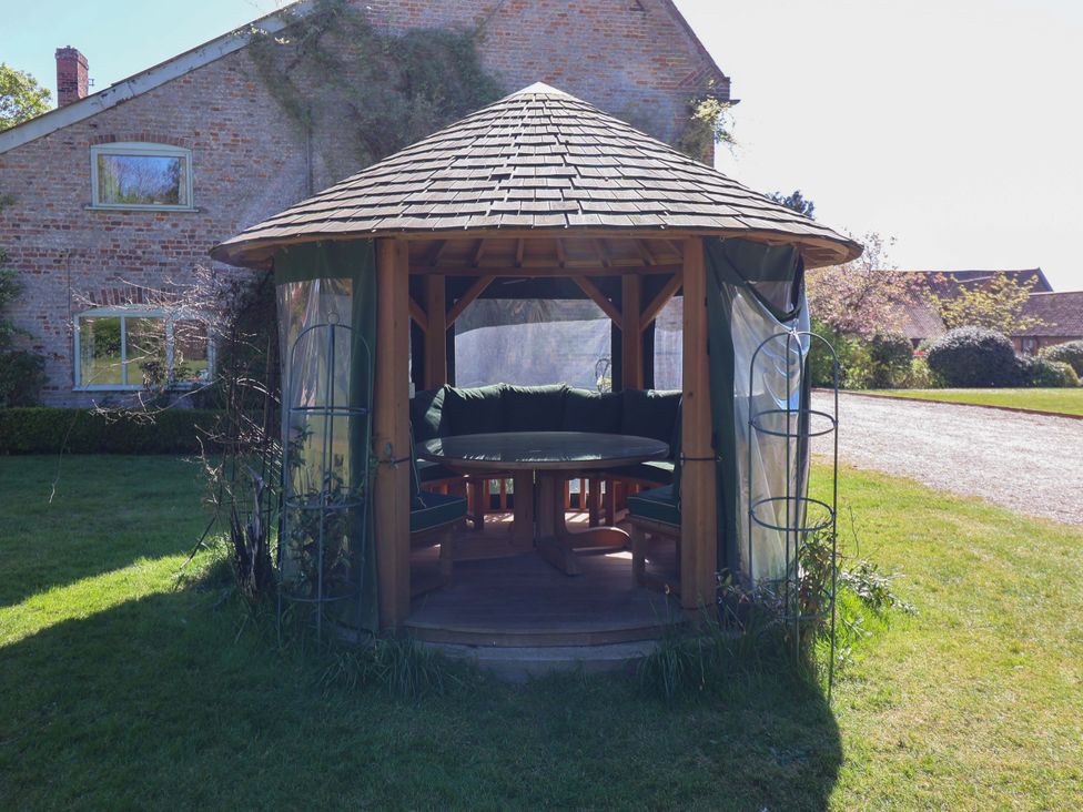 A gazebo with seating in a garden at Winston Hall in Beccles