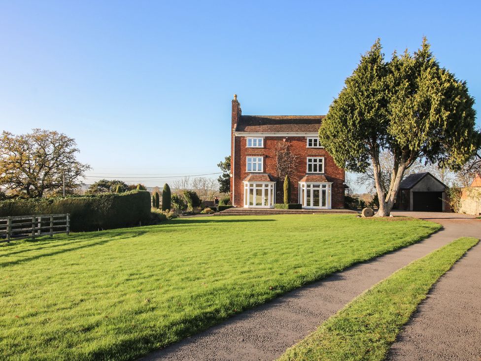 A house with large windows and grass area at The Mill House