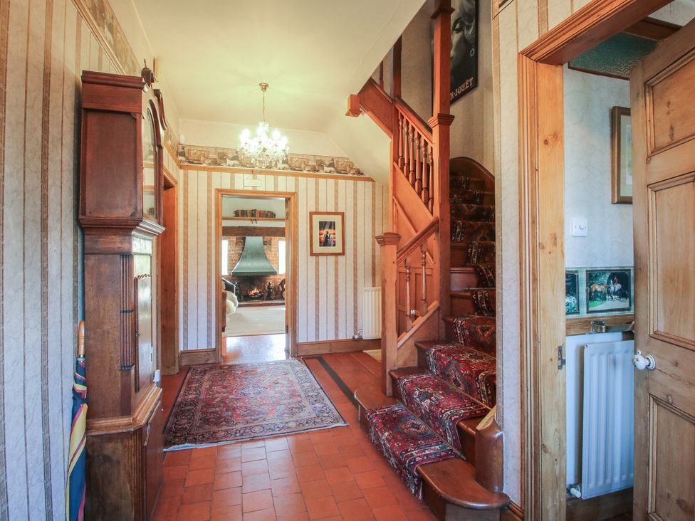 A hallway with a staircase and decorative elements at The Mill House