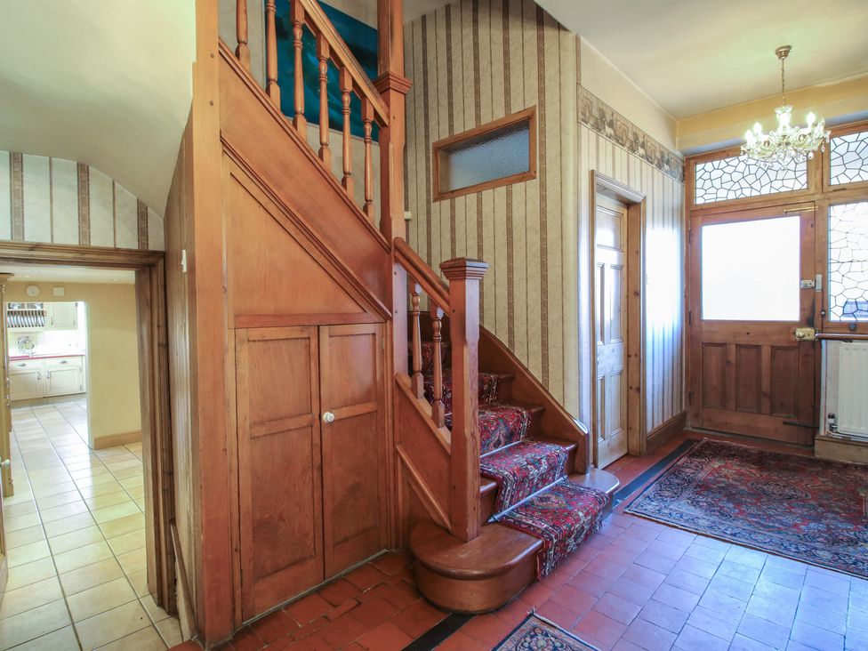 A hallway with a staircase and closet at The Mill House in 