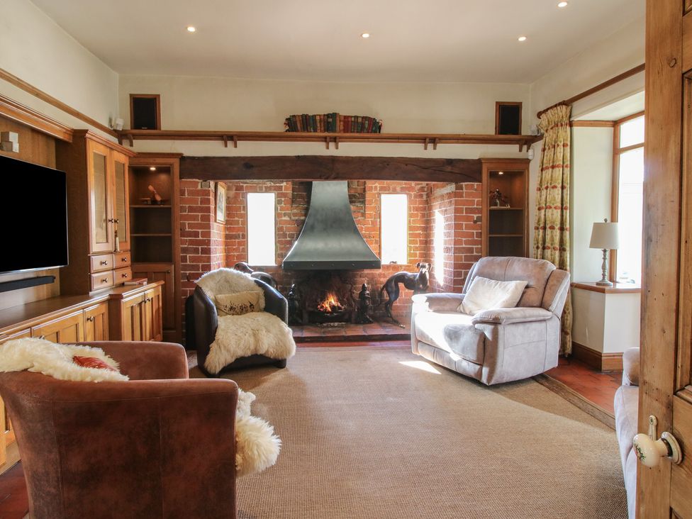 A living room with a fireplace and seating at The Mill House in 