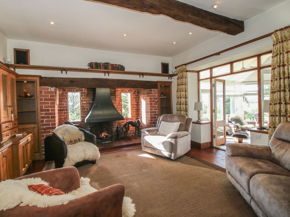 A living room with a fireplace and seating at The Mill House in 