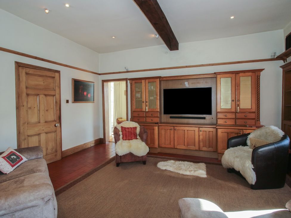 A living room with a sofa and television unit at The Mill House 