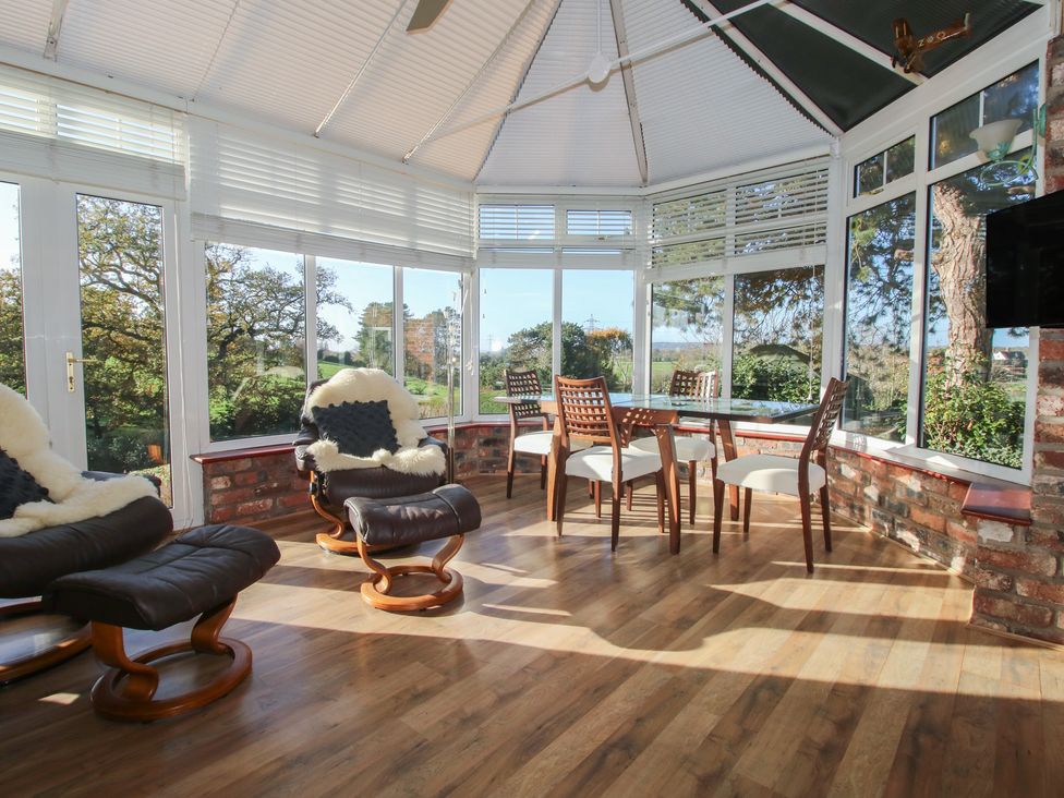 A conservatory with seating and a table at The Mill House in 
