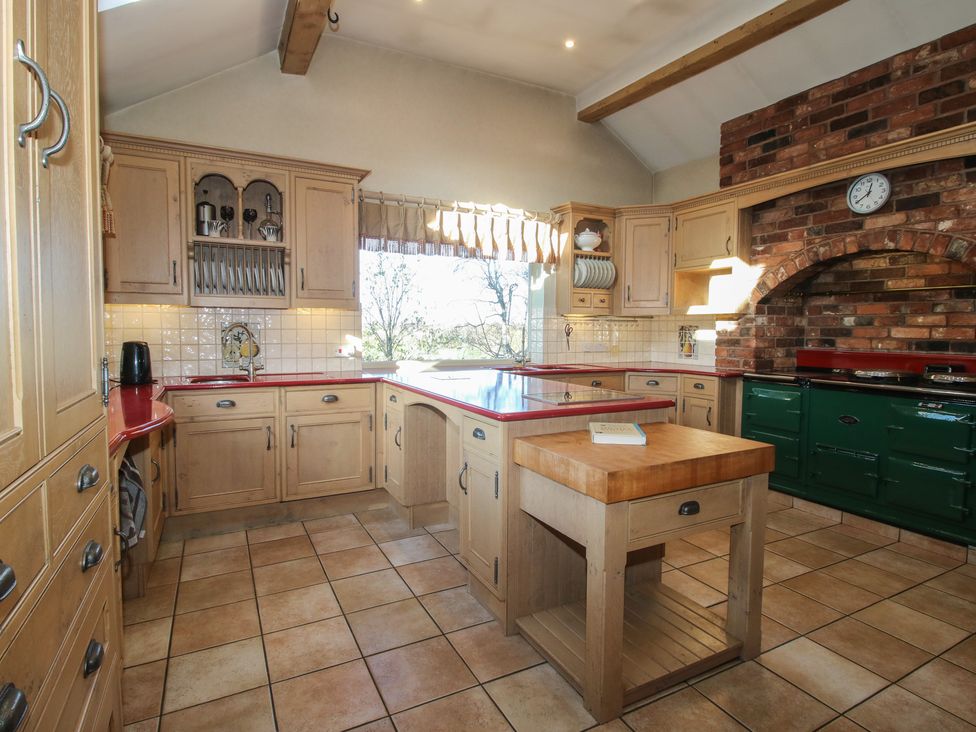 A kitchen with cabinets and an island at The Mill House