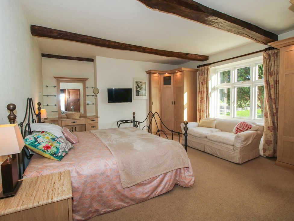 A bedroom with a bed and wardrobe at The Mill House 