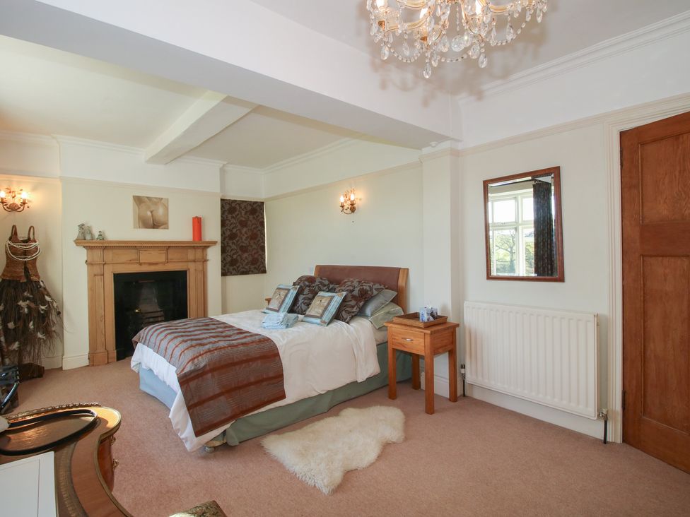 A bedroom with a bed and side table at The Mill House
