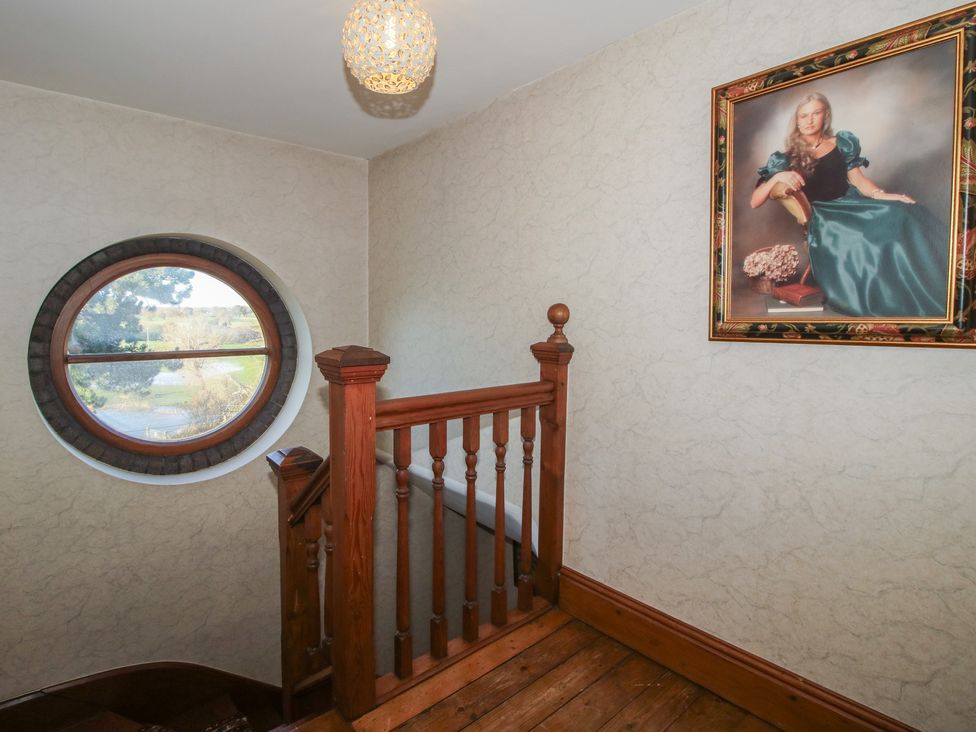 A staircase with a round window and painting at The Mill House in 