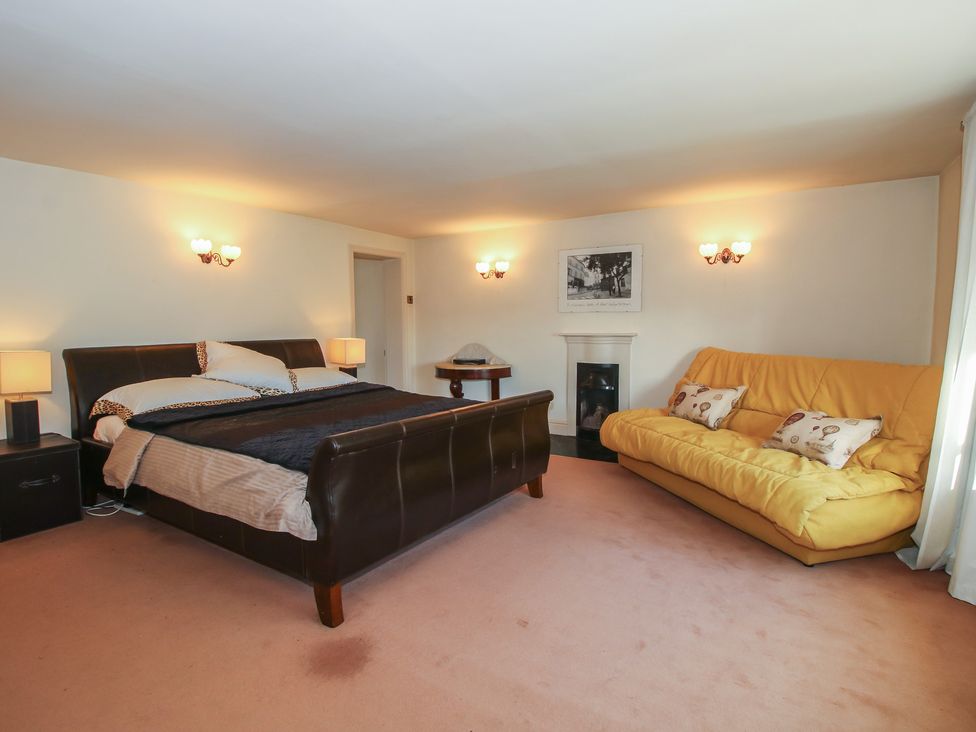 A bedroom with a bed and sofa at The Mill House