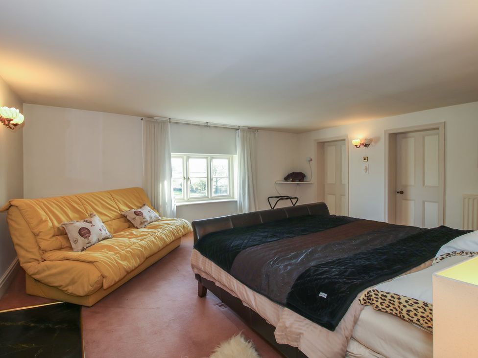 A bedroom with a bed and sofa at The Mill House in 