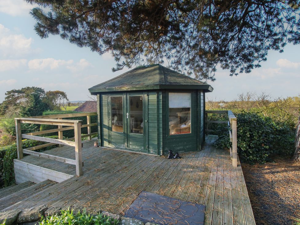 A garden shed with decking at The Mill House 