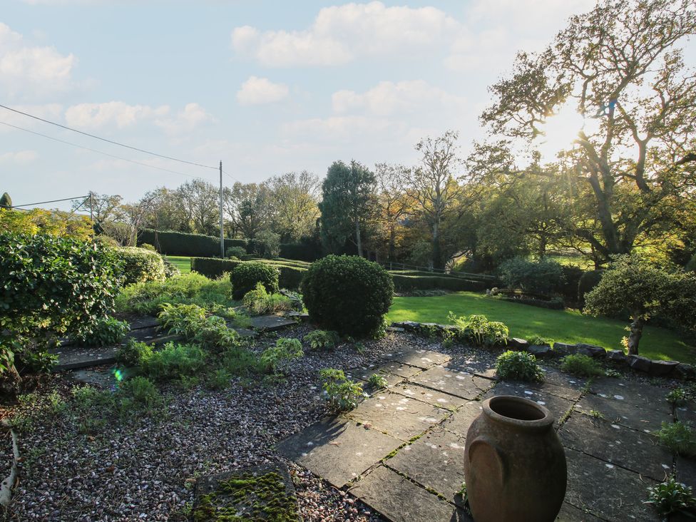 A garden with stone patio and potted plant at The Mill House