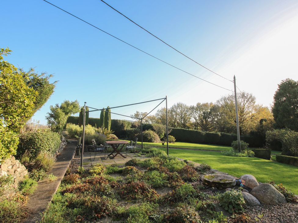 A garden with a table and chairs at The Mill House in 