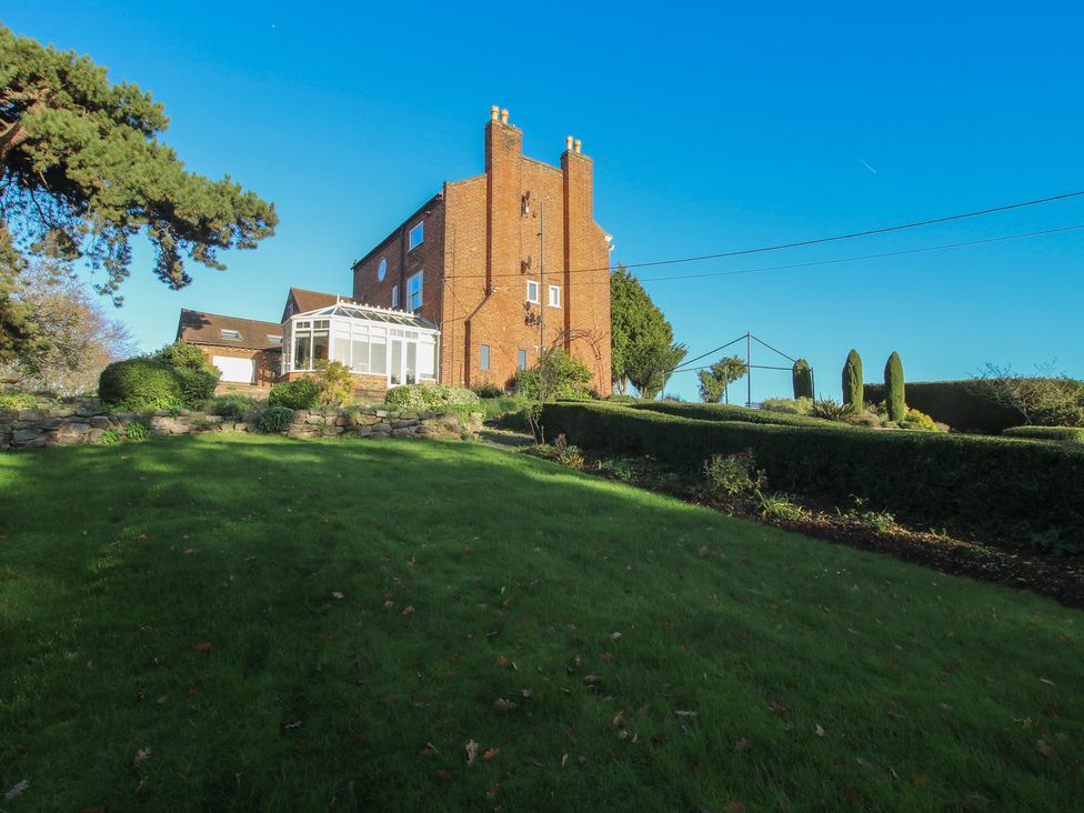 A house with a conservatory and garden area at The Mill House 