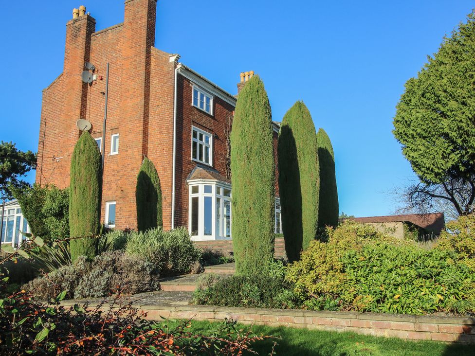 A house with trees and bushes in the garden at The Mill House 
