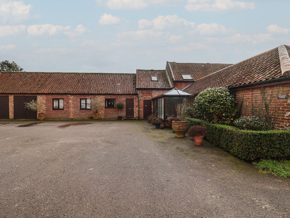 An outdoor area with multiple buildings and plants at Winston Lodge in Beccles