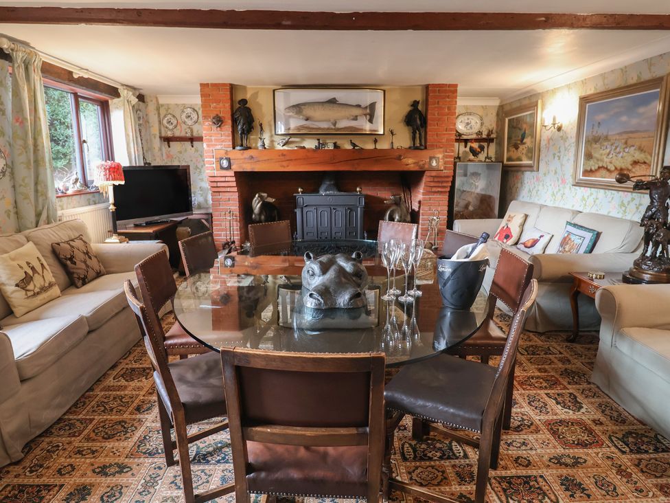 A living room with a dining table and sofa at Winston Lodge in Beccles