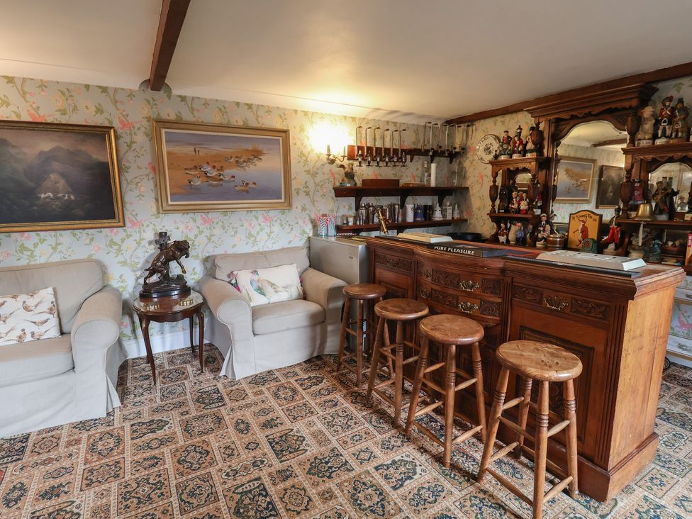 A snug with a bar and seating area at Winston Lodge in Beccles