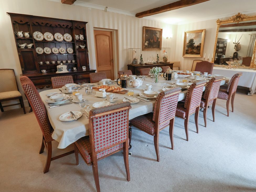 A dining room with a table set for a meal at Winston Lodge in Beccles