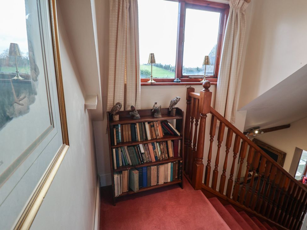 A staircase with a bookshelf and window at Winston Lodge in Beccles