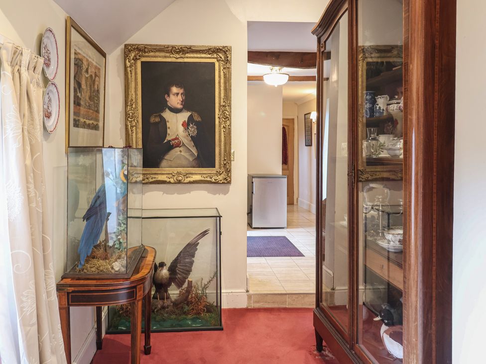 A hallway with a painting and display cabinet at Winston Lodge in Beccles